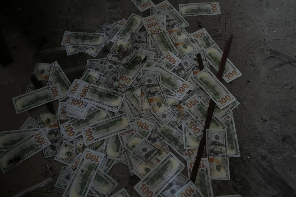 Fake dollar bills lie on the floor at a scam center in O'Smach, Cambodia, Monday, Feb. 2, 2026. (AP Photo/Sakchai Lalit)