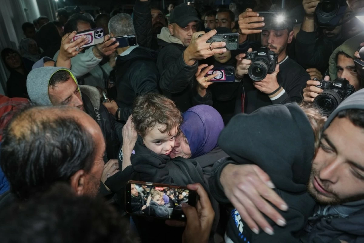 Najat Rubaie, center right, embraces one of her grandsons after they arrive with their mother as part of a group of about a dozen Palestinian returnees allowed into Gaza following the long-awaited reopening of the Rafah border crossing, at Nasser Hospital in Khan Younis, southern Gaza Strip, early Tuesday, Feb. 3, 2026. (AP Photo/Abdel Kareem Hana)