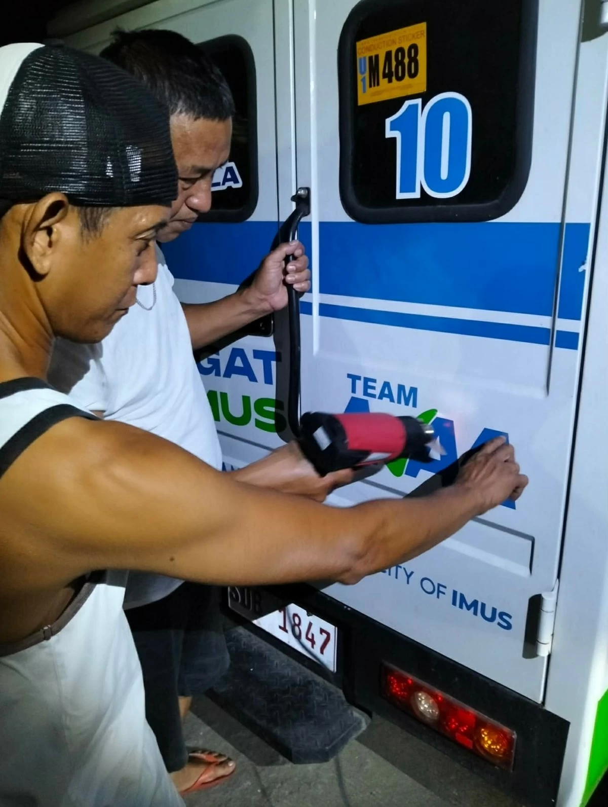 Personnel remove names of politicians from a barangay vehicle in Imus City (Photo from the City Government of Imus’ Facebook page/MANILA BULLETIN)