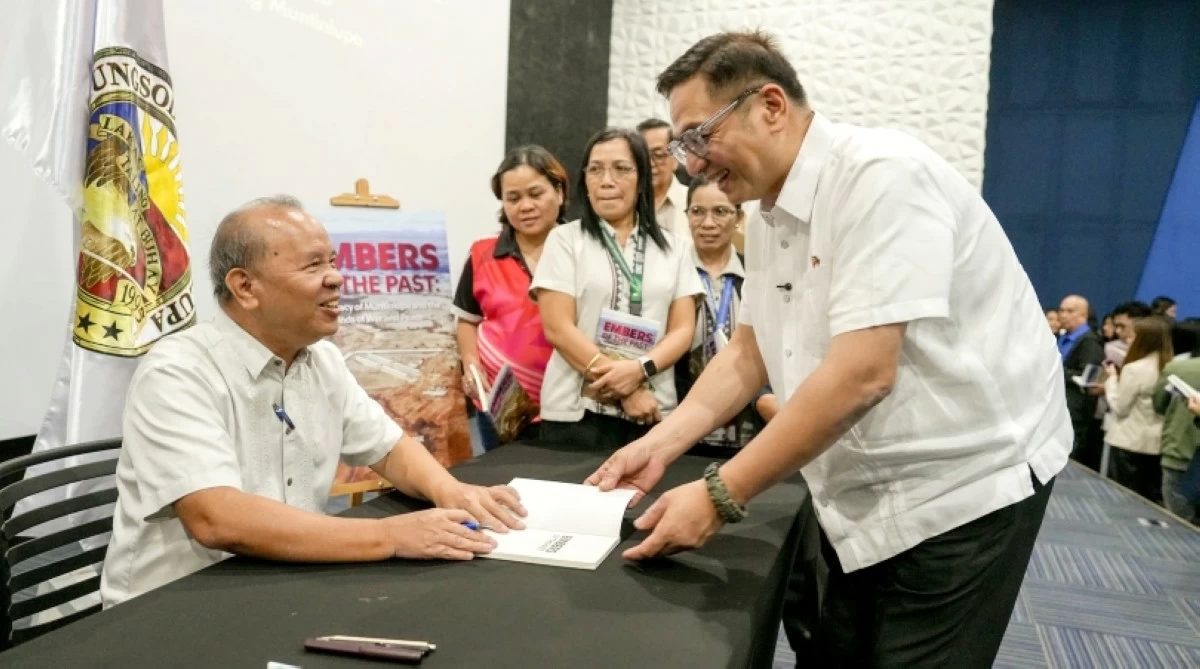 Author Ricardo Jose (left) of the book “Embers of the Past: The Legacy of Muntinlupa and The Bonds of War and Peace” signing a copy for Muntinlupa Mayor Ruffy Biazon (Photo from Muntinlupa PIO)  