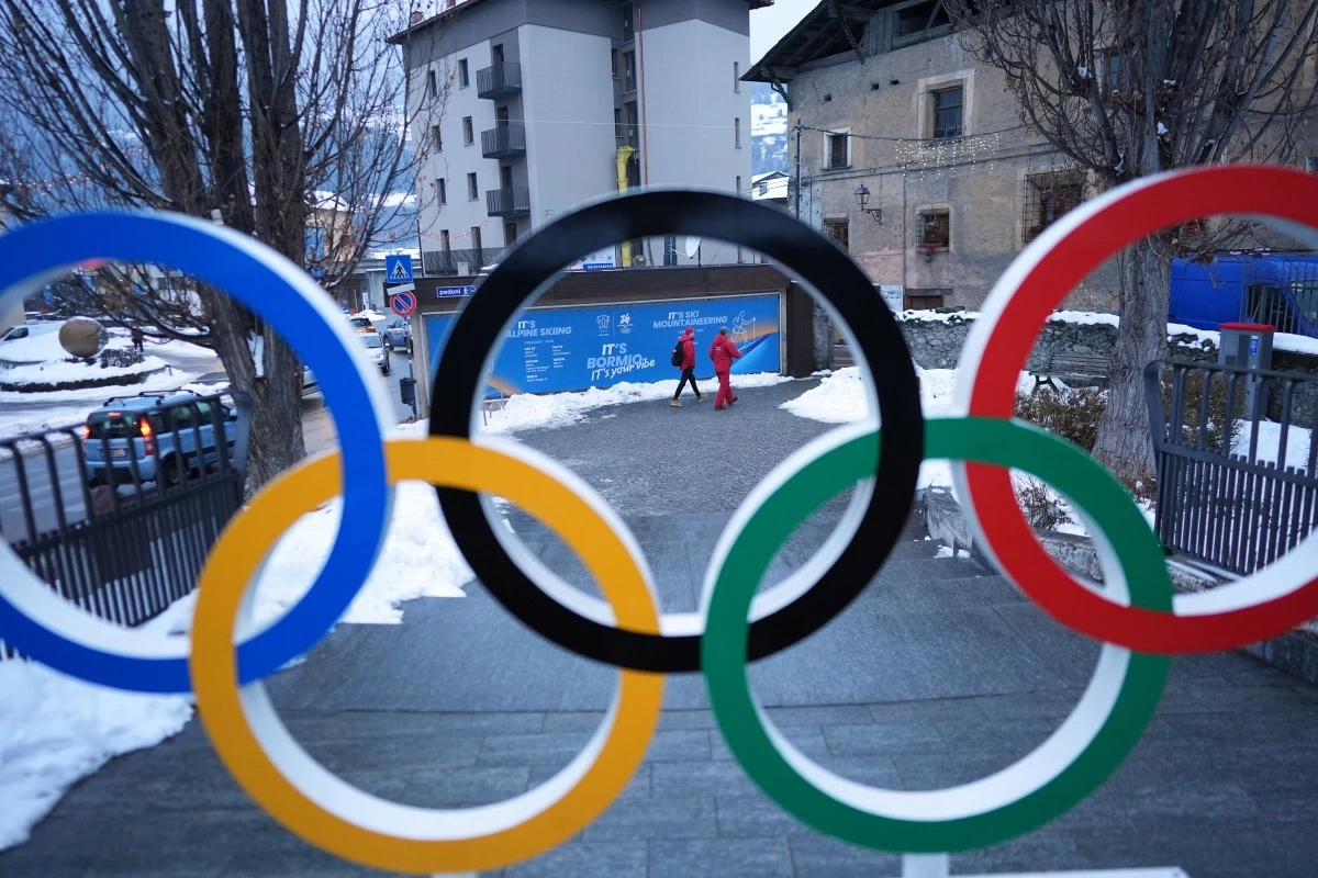 People walk past Olympic rings at the 2026 Winter Olympics, in Bormio, Italy, Wednesday, Feb. 4, 2026. (AP Photo/Rebecca Blackwell)