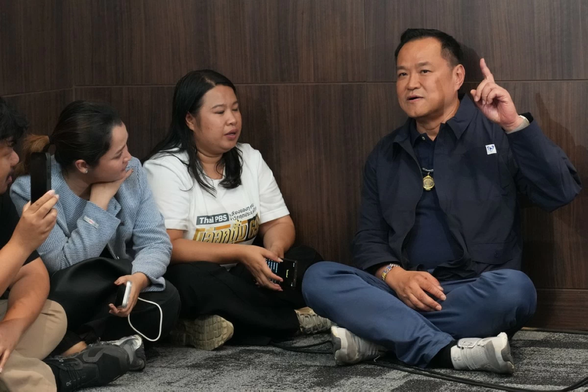 Thailand's Prime Minister and leader of Bhumjaithai Party Anutin Charnvirakul, right, speaks with journalists at the party headquarters while waiting for the results in the general election in Bangkok, Sunday, Feb. 8, 2026. (AP Photo/Sakchai Lalit)