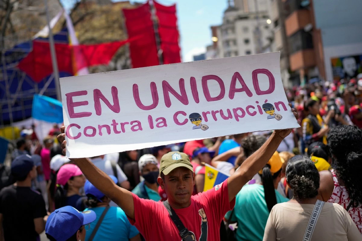 A government supporter holds a sign with a message that reads in Spanish: 