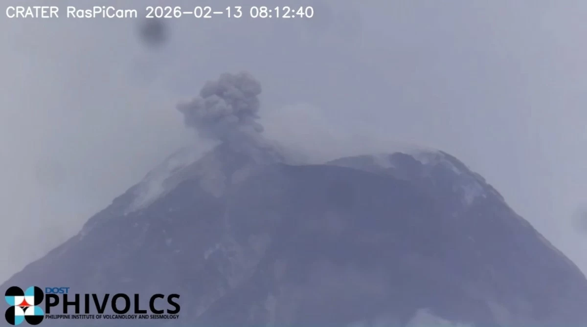 Mayon Volcano releases a grayish ash plume from its summit crater on Feb. 13, 2026, rising about 50 meters before drifting west-southwest, as recorded by monitoring cameras of the Philippine Institute of Volcanology and Seismology. The volcano remains under Alert Level 3 amid continued effusive activity, including lava flows, rockfalls, and intermittent pyroclastic density currents. (Phivolcs/Screenshot)