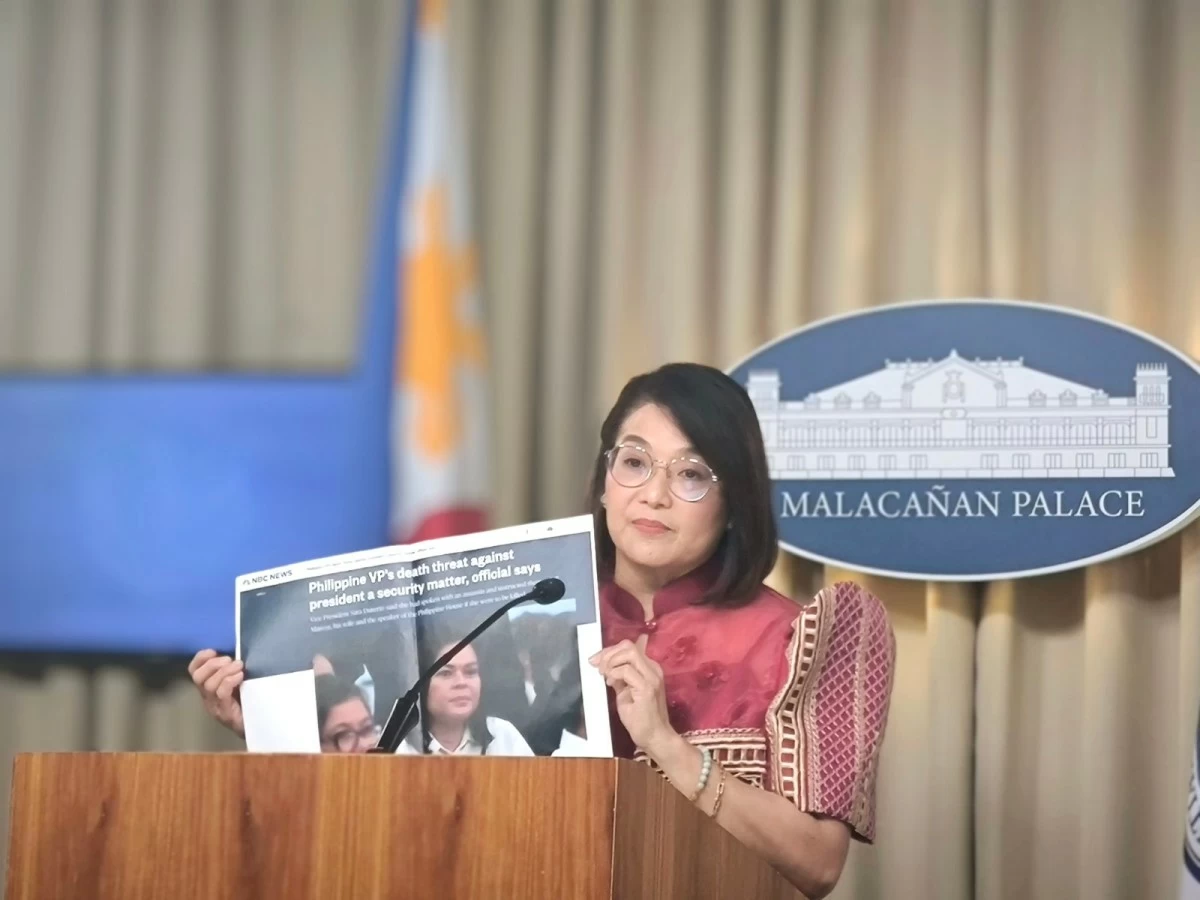 Palace Press Officer and Communications Undersecretary Claire Castro shows a copy of a news report about Vice President Sara Duterte's alleged threats to President Ferdinand R. Marcos Jr. during a Palace briefing on Feb. 13, 2026. (Betheena Unite)