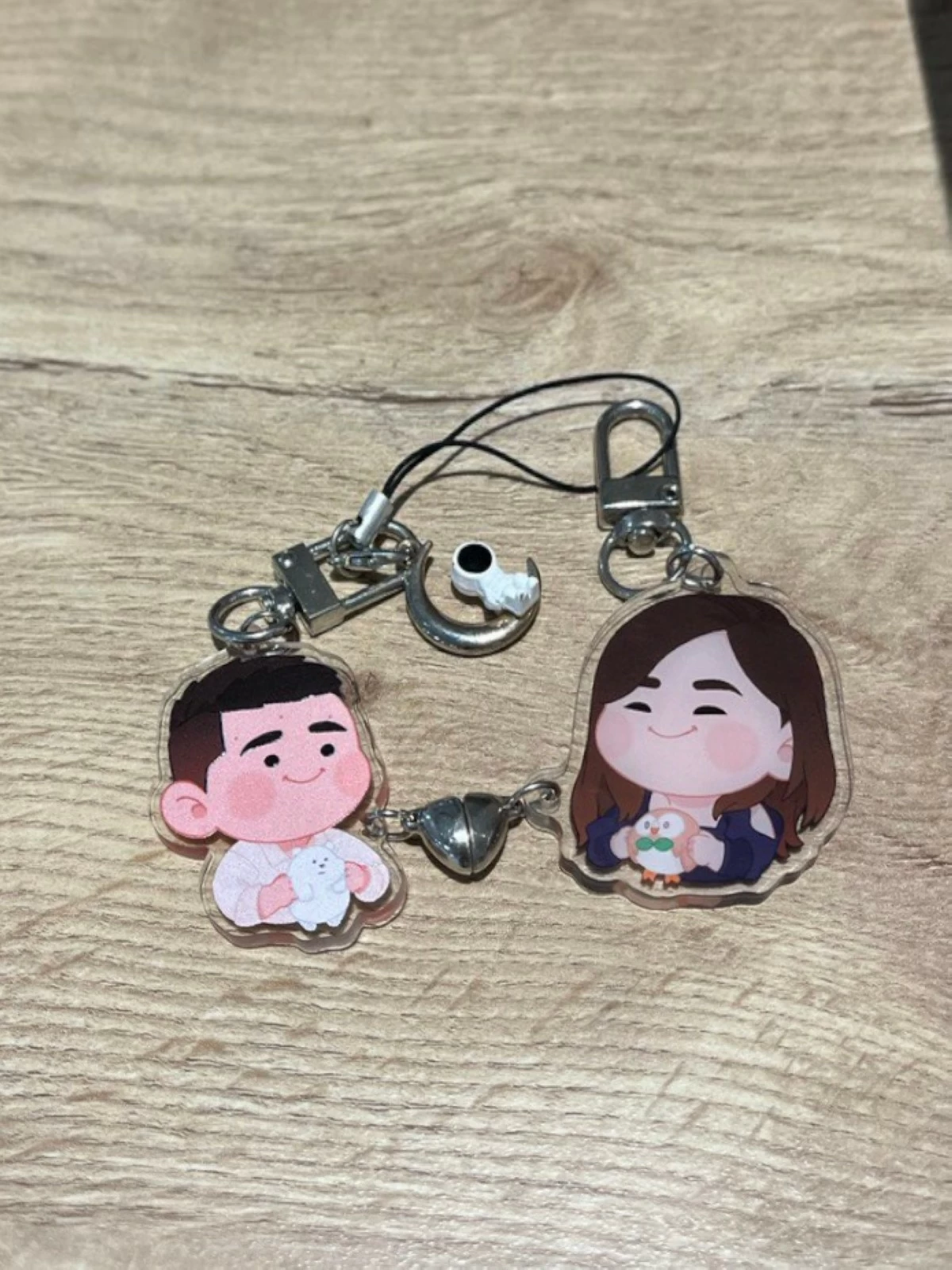 Customized keychain with a portrait of Caroline and Louis by artist @Oywo_ on X.