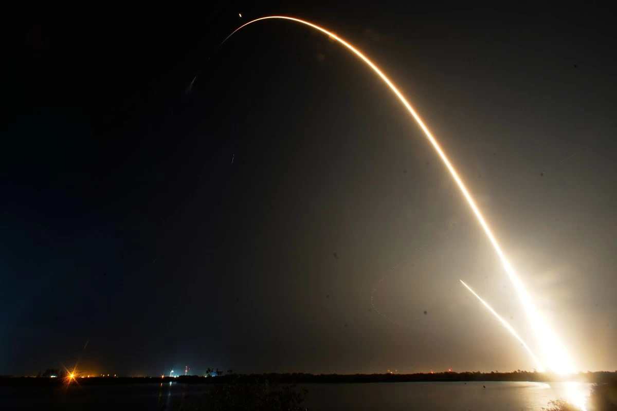 A SpaceX Falcon 9 rocket with a crew of four aboard the Dragon space craft is seen during a time exposure as it lifts off from pad 40 at the Cape Canaveral Space Force Station in Cape Canaveral, Florida, Friday, Feb. 13, 2026, as a second streak just to the left is the booster on a return landing at the launch pad. (AP)