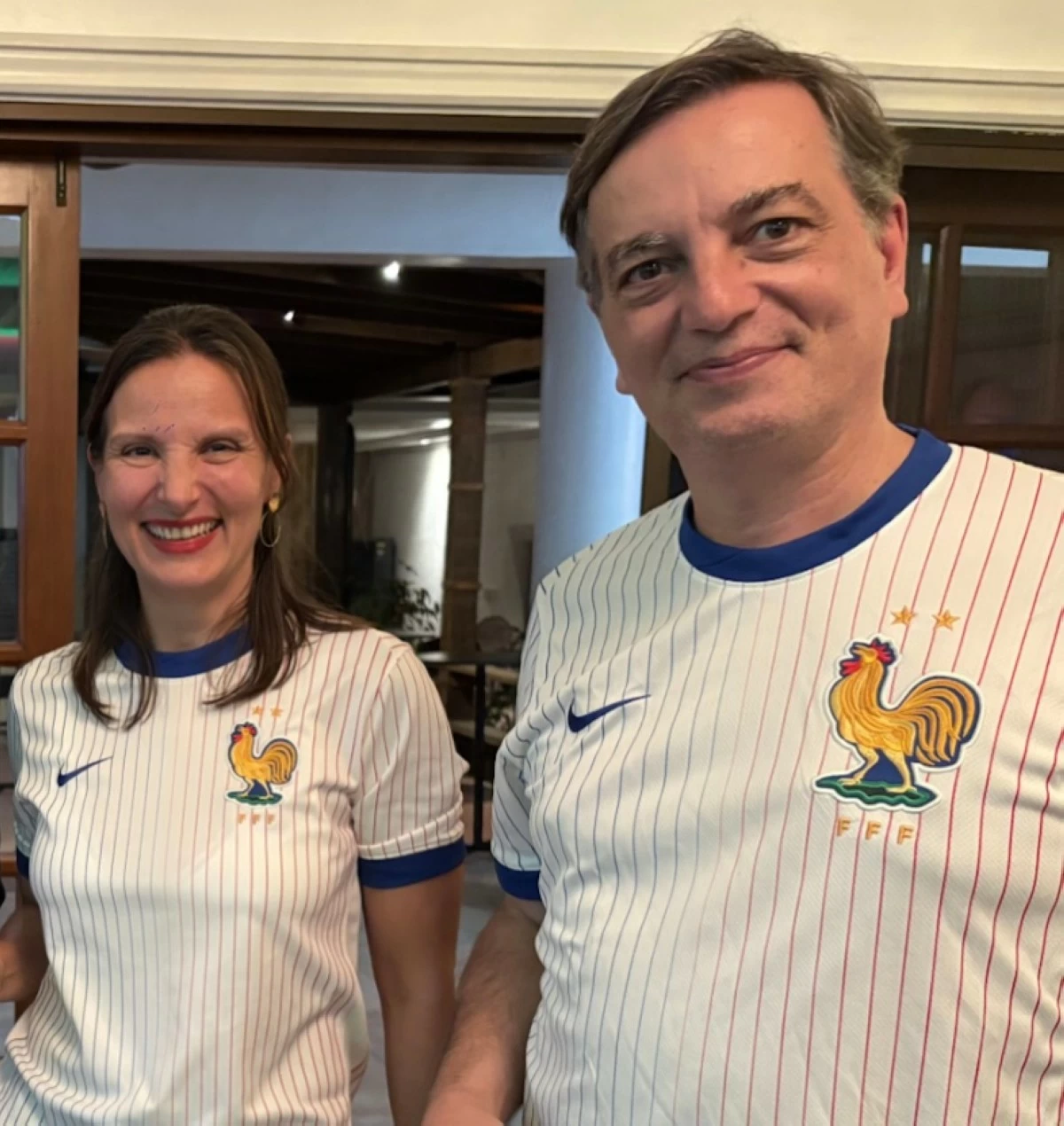 French Ambassador Marie Aude Françoise Lassalle ep. Fontanel and her spouse Alain Fontanel stand tall, proudly donning jerseys emblazoned with the Gallic rooster—a bold emblem of French resilience and sporting spirit