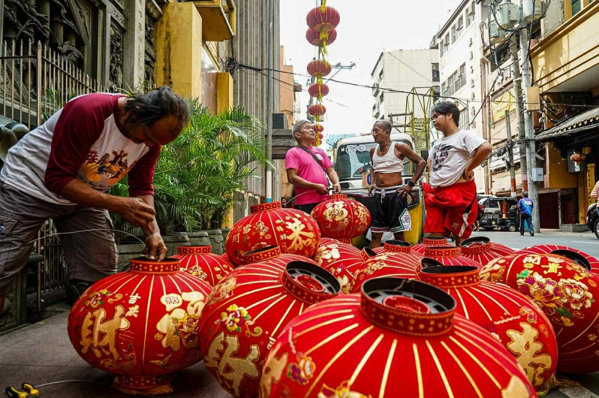 Workers install Chinese lanterns along Narra Street in Manila on Tuesday, Feb.10, in preparation for the Lunar New Year. (John Louie Abrina)