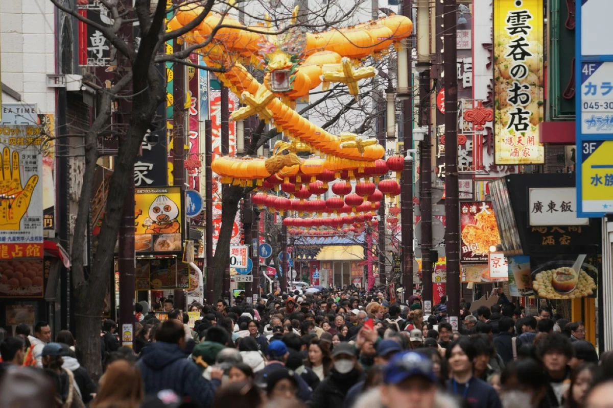 Visitors stroll a street decorated with a big dragon shaped lantern for their Chinese Lunar New Year celebrations, marking the Year of the Horse on the Chinese zodiac, Tuesday, Feb. 17, 2026, at China Town in Yokohama near Tokyo. (AP Photo/Eugene Hoshiko)