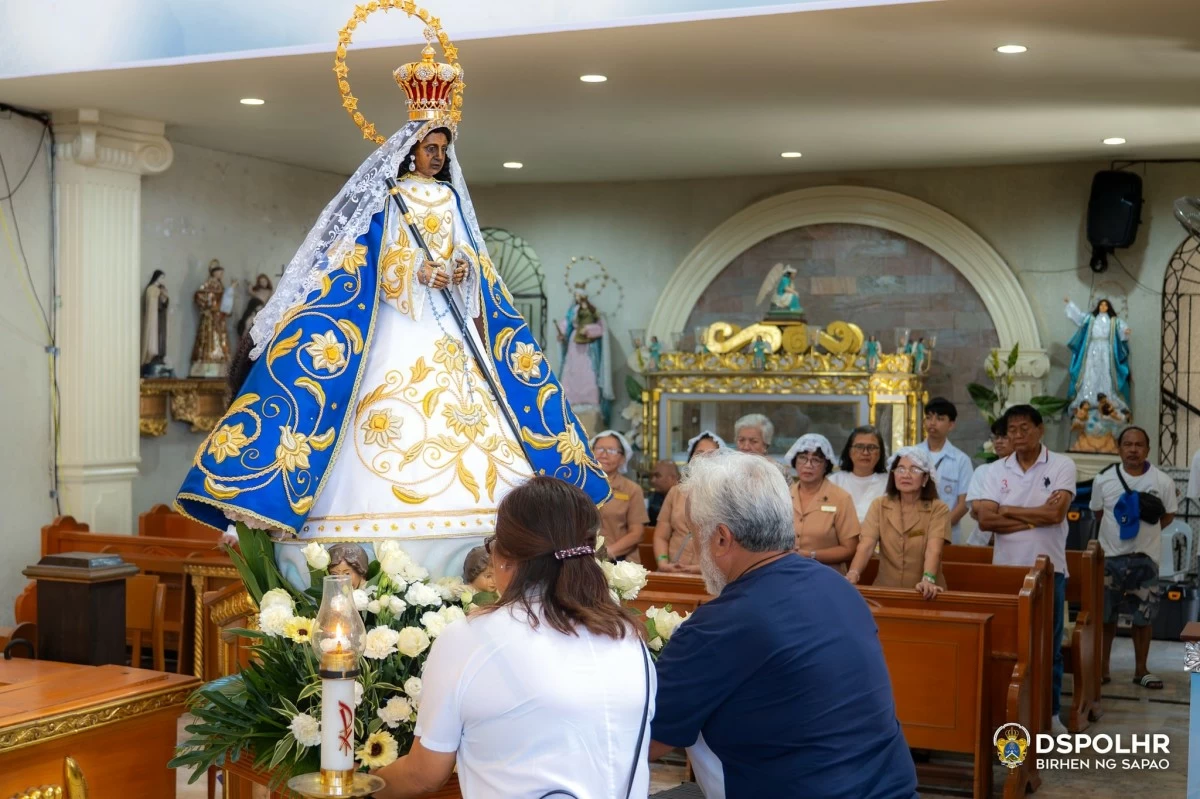 The Reyes couple offers flowers at the image of the Our Lady of Peace and Good Voyage. (Photo from La Virgen de Sapao's FB page)