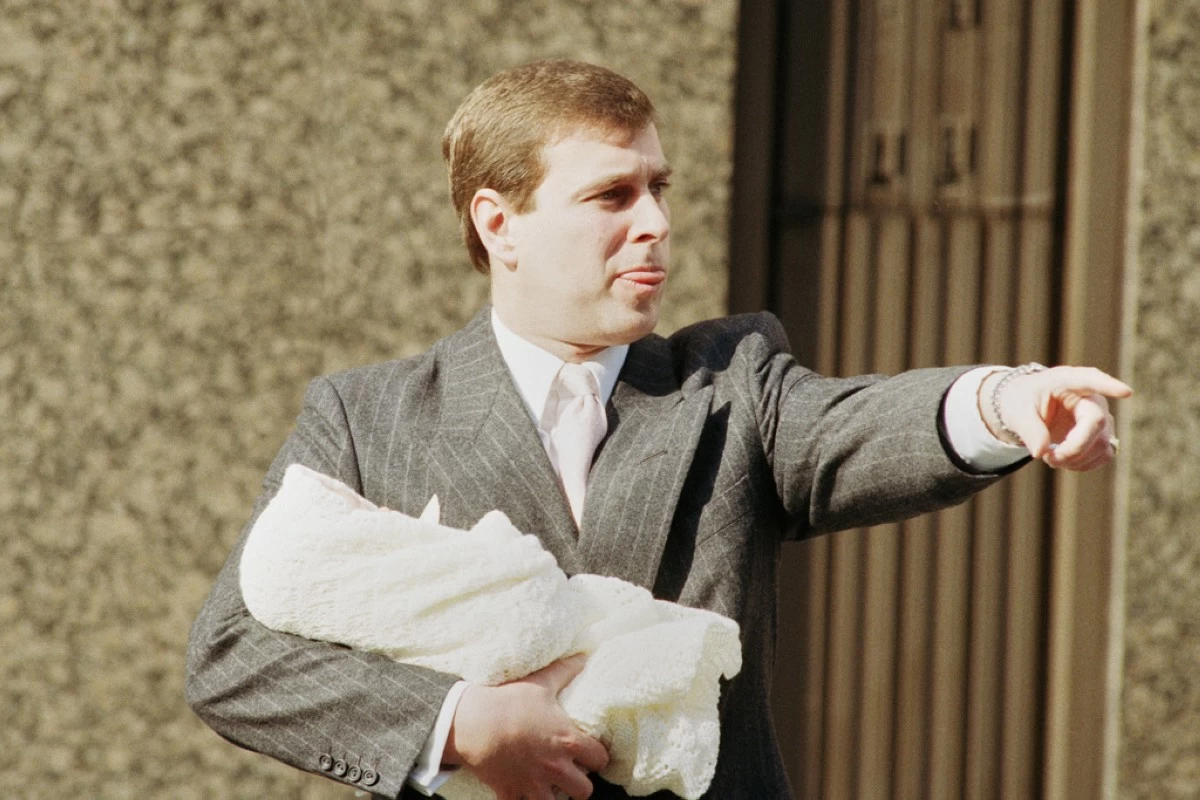 The Duke of York holds week-old Princess Eugenie Victoria Helena outside Portland Hospital in London, March 30, 1990. (AP Photo/Peter Kemp, File)