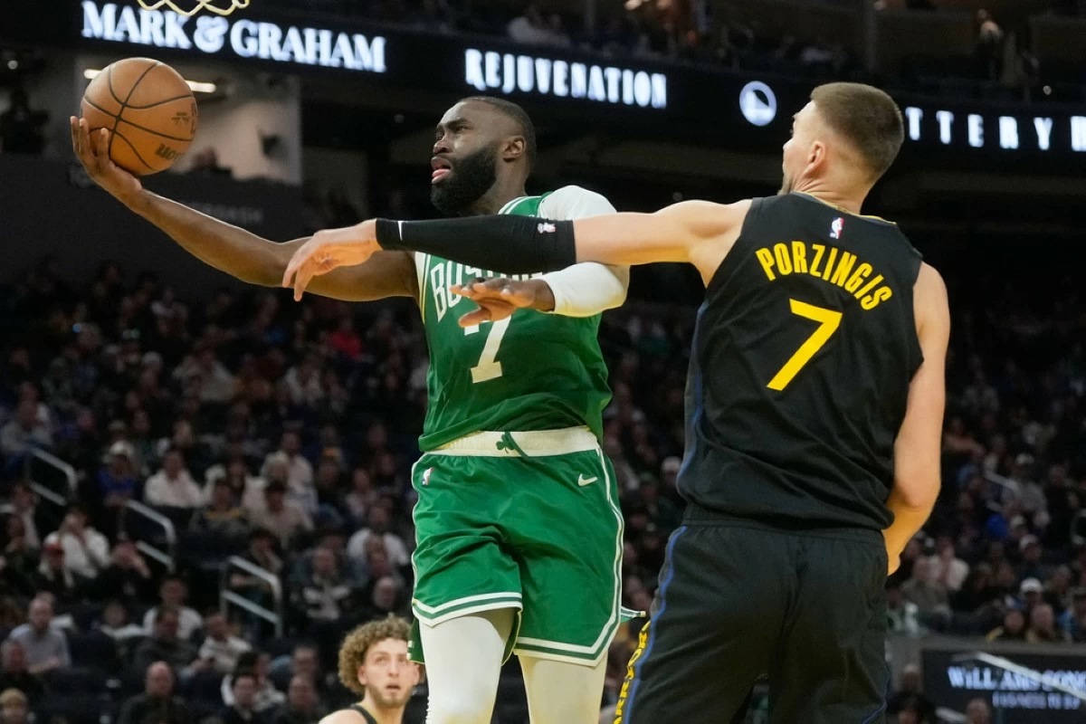 Boston Celtics guard Jaylen Brown, left, shoots against Golden State Warriors center Kristaps Porziņģis during the second half of an NBA basketball game in San Francisco, Thursday, Feb. 19, 2026. (AP Photo/Jeff Chiu)