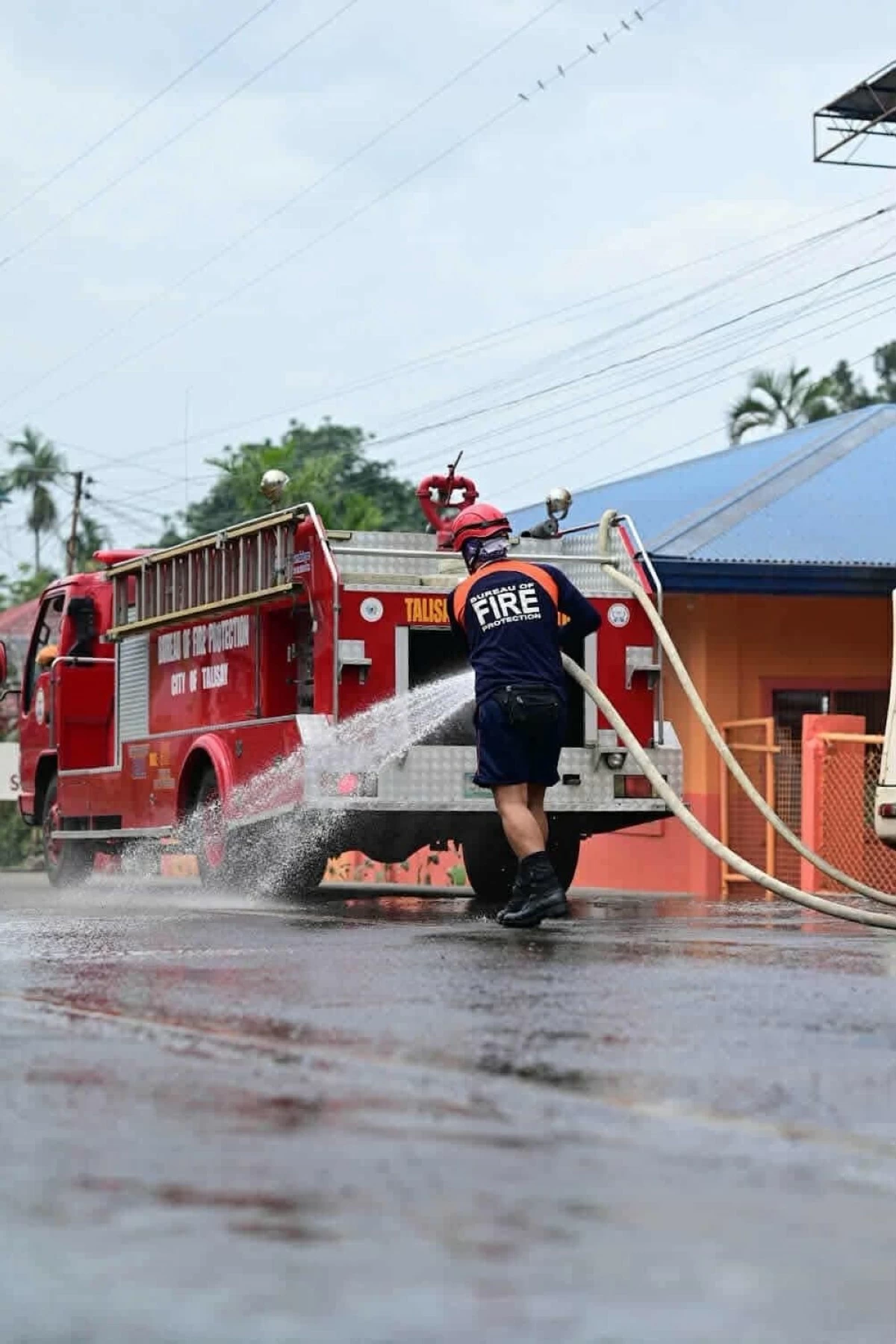 FIREMEN clean La Carlota City of Kanlaon’s ash. (La Carlota City PIO) 