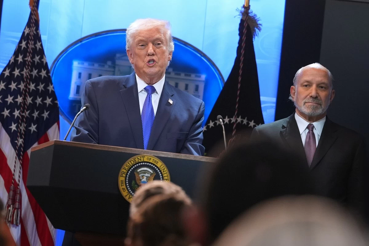 President Donald Trump speaks during a press briefing at the White House, Friday, Feb. 20, 2026, in Washington, as Commerce Secretary Howard Lutnik, looks on. (AP Photo/Evan Vucci)