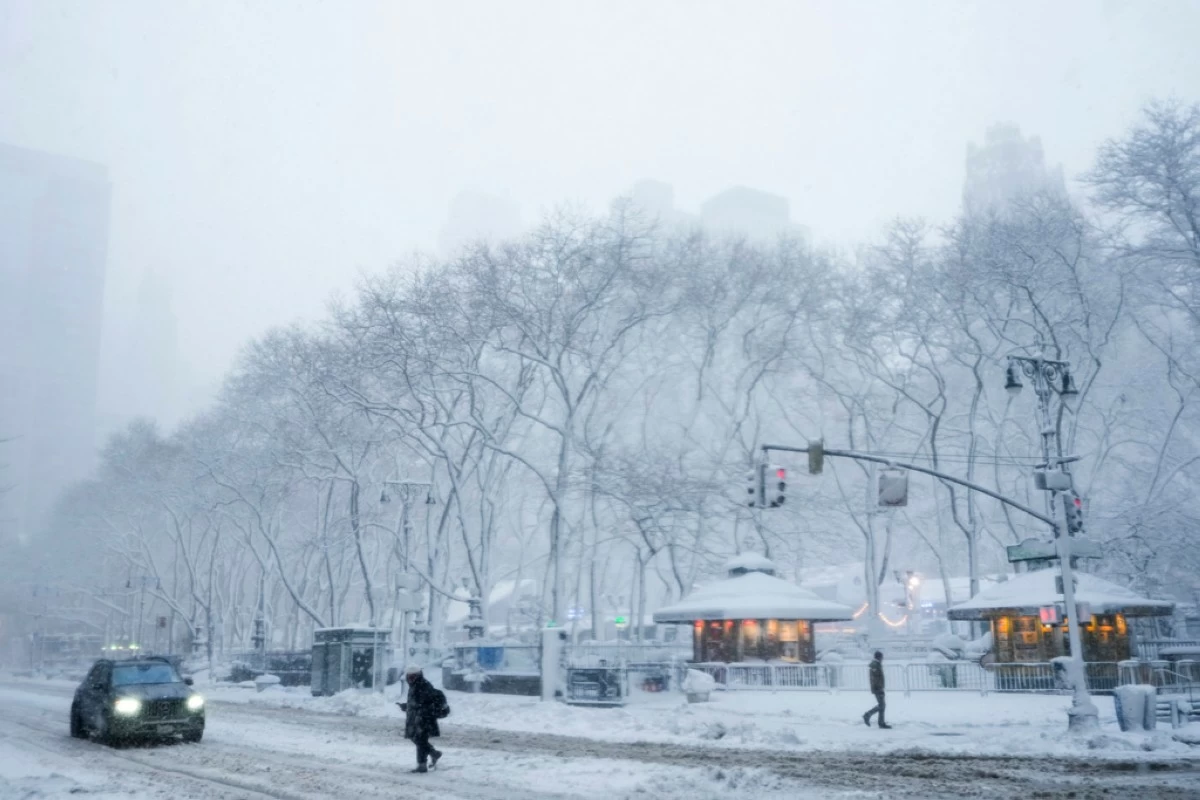 A pedestrian crosses a snow-covered 42nd Street near Bryant Park, Monday, Feb. 23, 2026, in New York. (AP Photo/Seth Wenig)