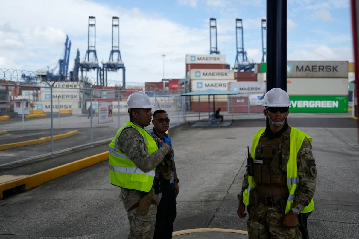 Workers stand at the entrance of the Balboa terminal, run by CK Hutchison's Panama Ports Co., after Panama government ordered the occupation of the port following a Supreme Court ruling that the concession was unconstitutional inPanama City, Panama, Monday, Feb. 23, 2026. (AP Photo/Matias Delacroix)