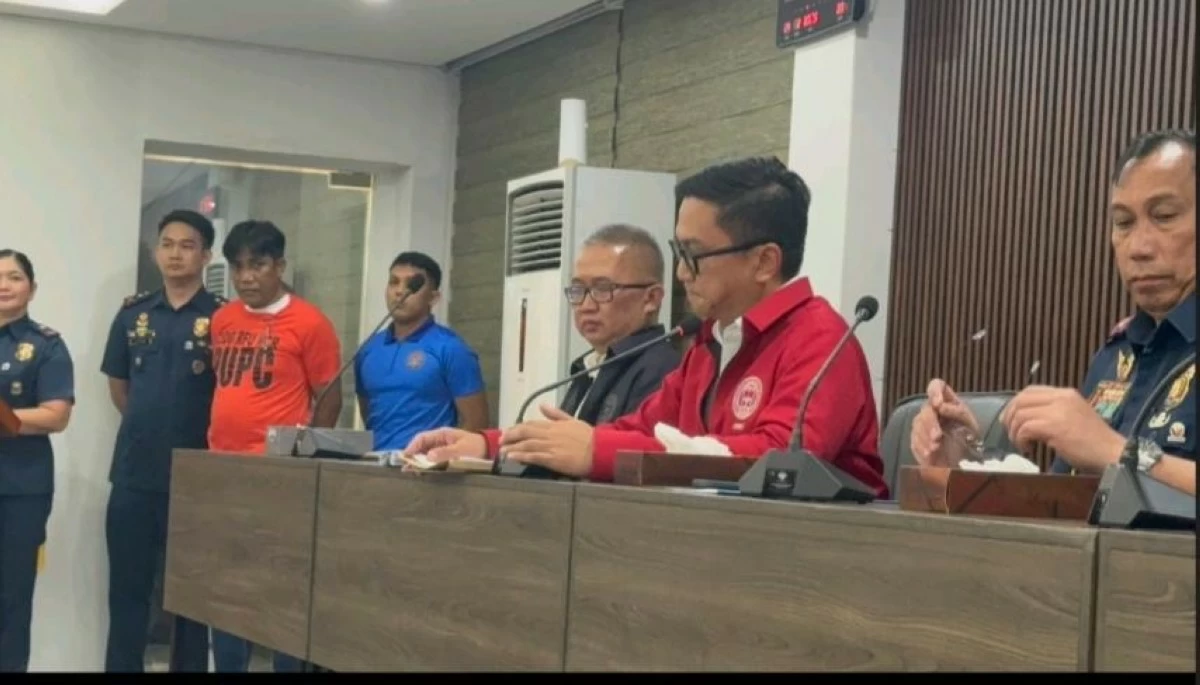 Napolcom vice hairman and executive officer Ralh Calinisan presents vlogger Norman Mangusin in a press briefing at Camp Crame in Quezon City on Feb. 24, 2025. Mangusin, who uses the alias Francis Leo Marcos, was collared for a case of unjust vexation.