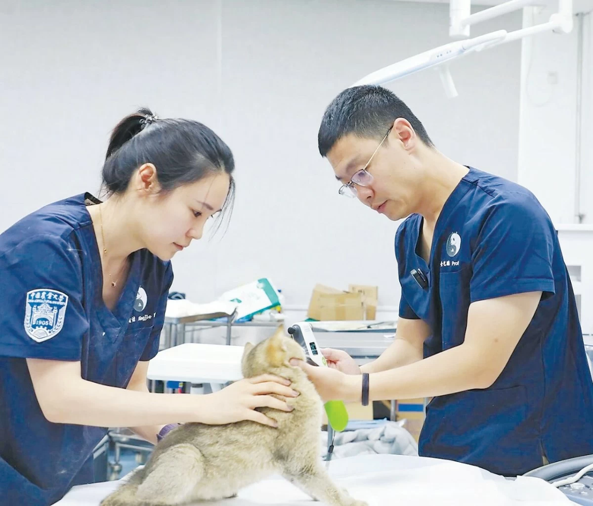 Jin Yipeng (right) guides a student in using the examination equipment. (Photo/Yang Hao)