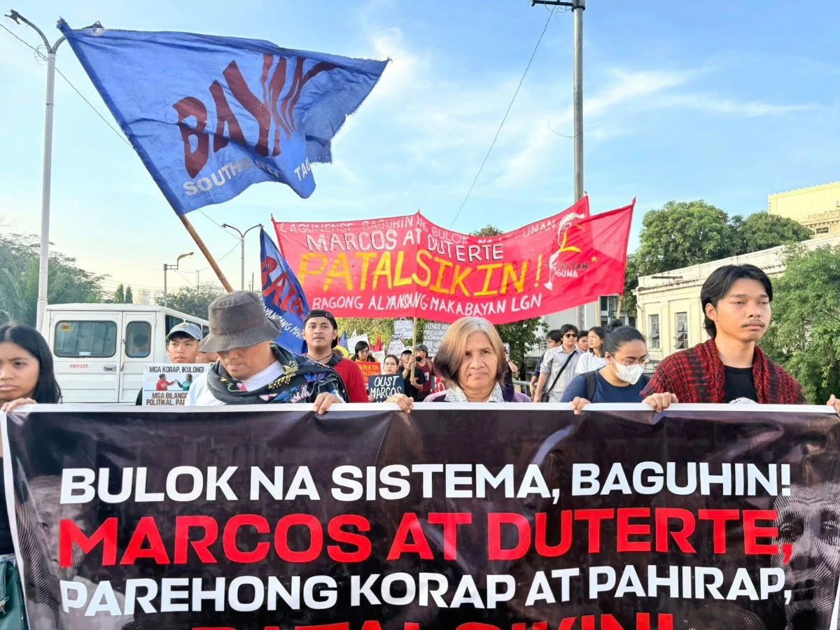 Protesters from Bagong Alyansang Makabayan arrive at Liwasang Bonifacio after holding a program in Sta. Cruz, Manila, during the EDSA anniversary mobilization.
