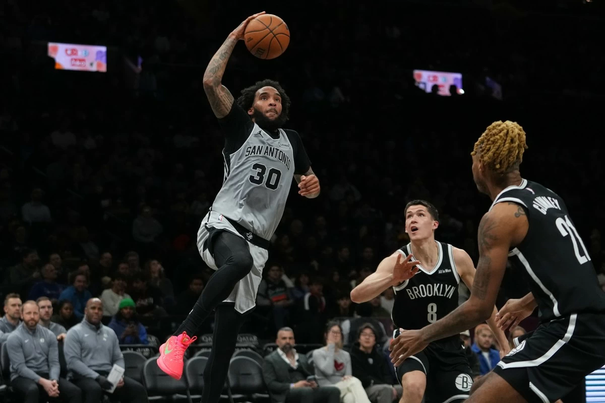 San Antonio Spurs' Julian Champagnie (30) shoots over Brooklyn Nets' Egor Dëmin (8) and Noah Clowney (21) during the second half of an NBA basketball game Thursday, Feb. 26, 2026, in New York. (AP Photo/Frank Franklin II)