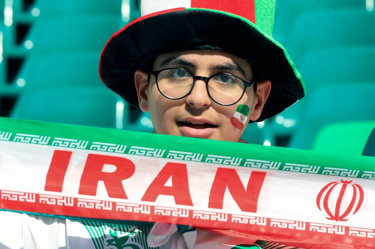FILE - An Iranian fan holds his national team banner prior to the Asian Cup quarterfinal soccer match between Japan and Iran at Education City Stadium in Al Rayyan, Qatar, Feb. 3, 2024. (AP Photo/Hussein Sayed, file)