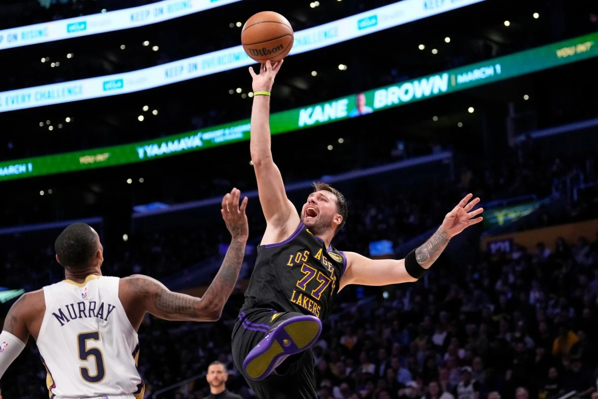 Los Angeles Lakers guard Luka Doncic, right, shoots as New Orleans Pelicans guard Dejounte Murray defends during the second half of an NBA basketball game Tuesday, March 3, 2026, in Los Angeles. (AP Photo/Mark J. Terrill)