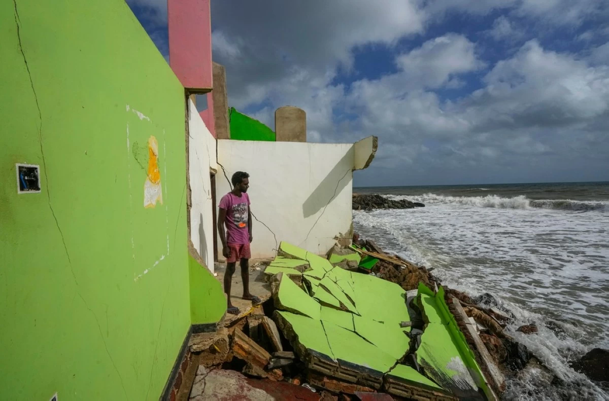 FILE - Dilrukshan Kumara looks at the ocean as he stands by the remains of his family's home in Iranawila, Sri Lanka, June 15, 2023. (AP Photo/Eranga Jayawardena, File)