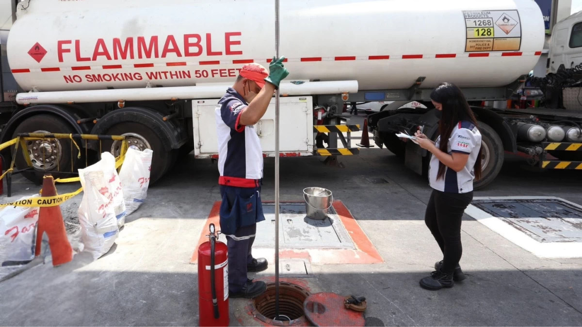 Pump attendants work together to refill a petrol station from an oil tanker in Quezon City on Friday, March 6. With another round of price hikes expected to be announced by the Department of Energy, the government is intensifying its monitoring of national fuel inventory to ensure stable supply. (Photo by: Santi San Juan I MB)