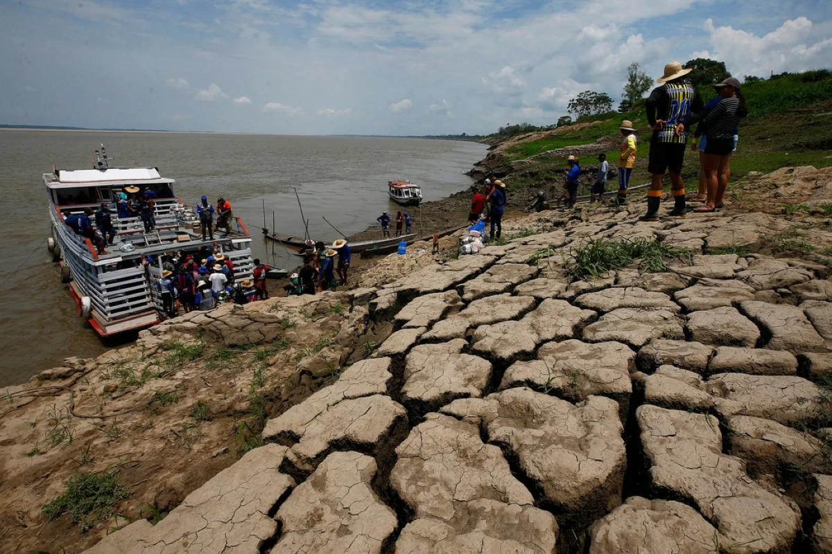 FILE - Residents of a riverside community carry food and containers of drinking water after receiving aid due to the ongoing drought in Careiro da Varzea, Amazonas state, Brazil, Oct. 24, 2023. (AP Photo/Edmar Barros, File)