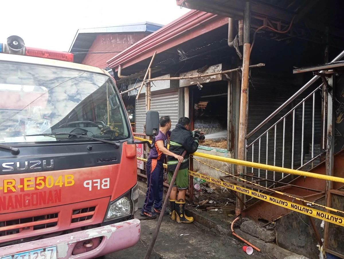Firemen aim their hose towards the interior of the fire-damaged Binangonan Public Market on March 7 (photo by Nel Andrade)