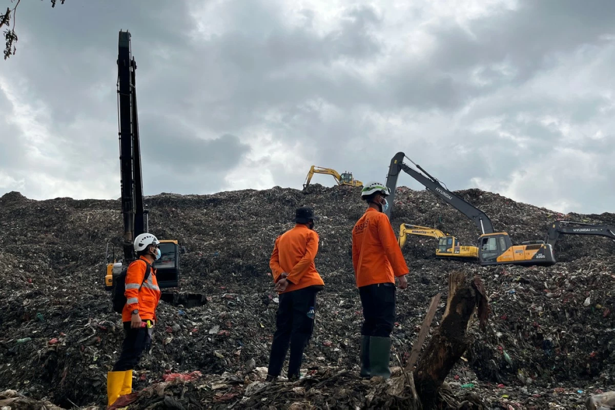 In this photo released by the Indonesian National Search and Rescue Agency (BASARNAS) on Monday, March 9, 2026, rescuers inspect the site of an avalanche of garbage that killed multiple people as heavy machines are used to search for victims at a landfill in Bantargebang, West Java, Indonesia. (BASARNAS via AP)