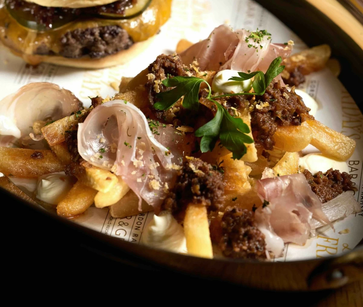 DIRTY FRIES Dirty fries topped with chili con carne, bacon bits, tomato salsa, and a rich Mornay sauce.