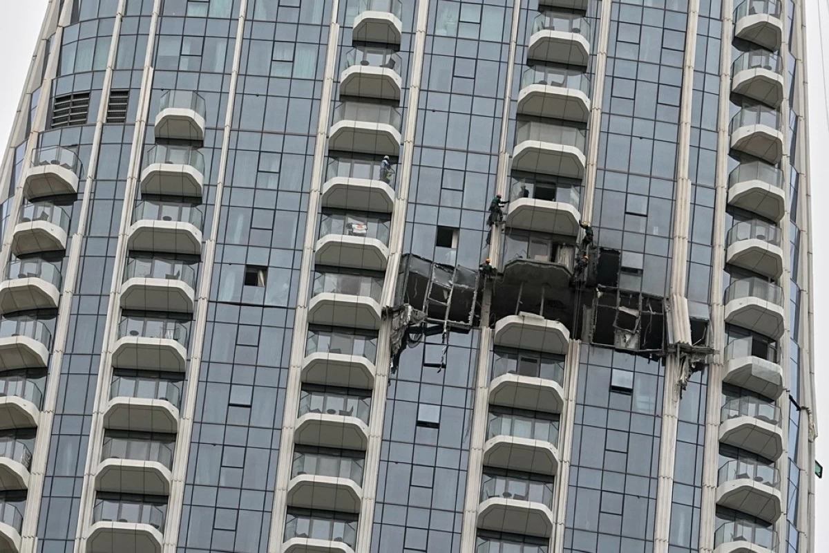 Workers inspect damage caused by a drone strike overnight at the Address Creek Harbour hotel in Dubai, United Arab Emirates, March 12, 2026. (AP Photo/Fatima Shbair)