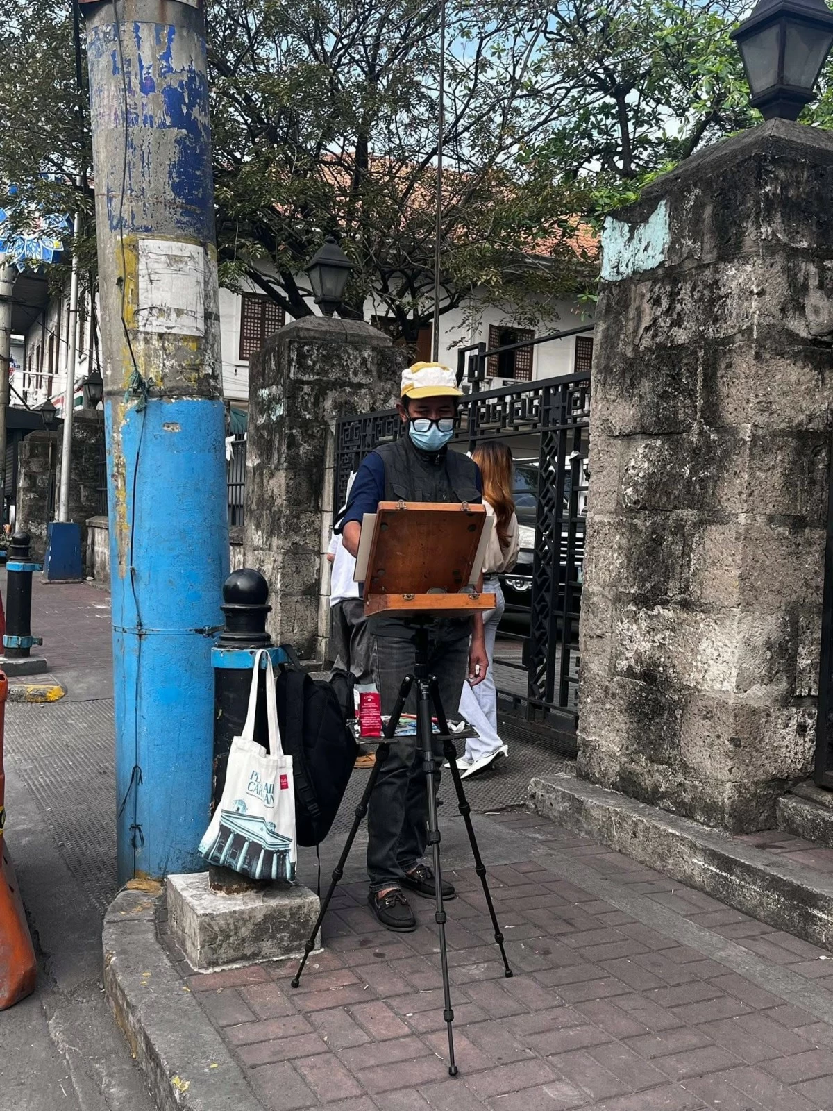 Erwin Mallari, 46, captures a Malabon streetscape on canvas during an outdoor painting session