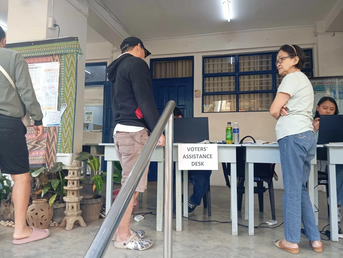 Staff of the Voters Assistance Desk assists a man in looking for his precinct (photo by Nel Andrade)


