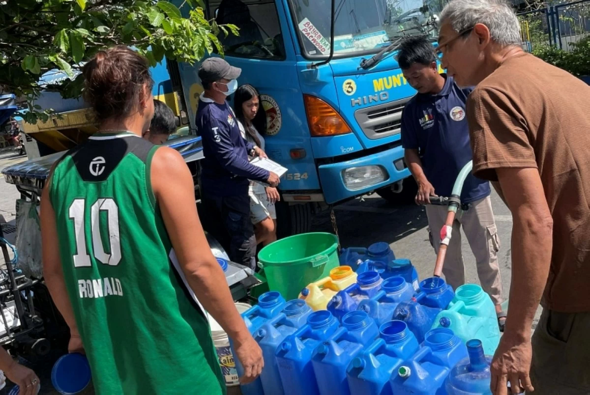 Muntinlupa City government personnel distributing  water to a community (Photo from Mayor Biazon's Facebook account) 