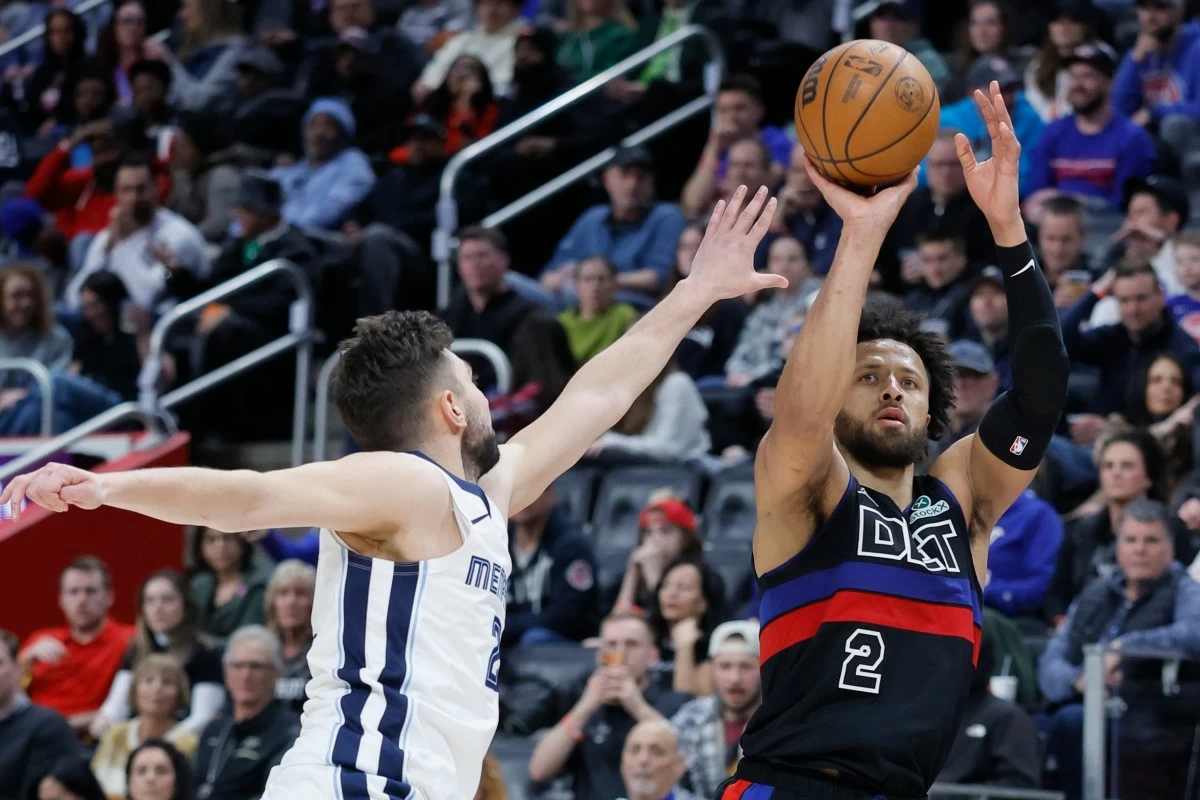 Detroit Pistons guard Cade Cunningham (2) takes a jump shot against Memphis Grizzlies guard Ty Jerome, left, during the second half of an NBA basketball game Friday, March 13, 2026, in Detroit. (AP Photo/Duane Burleson)