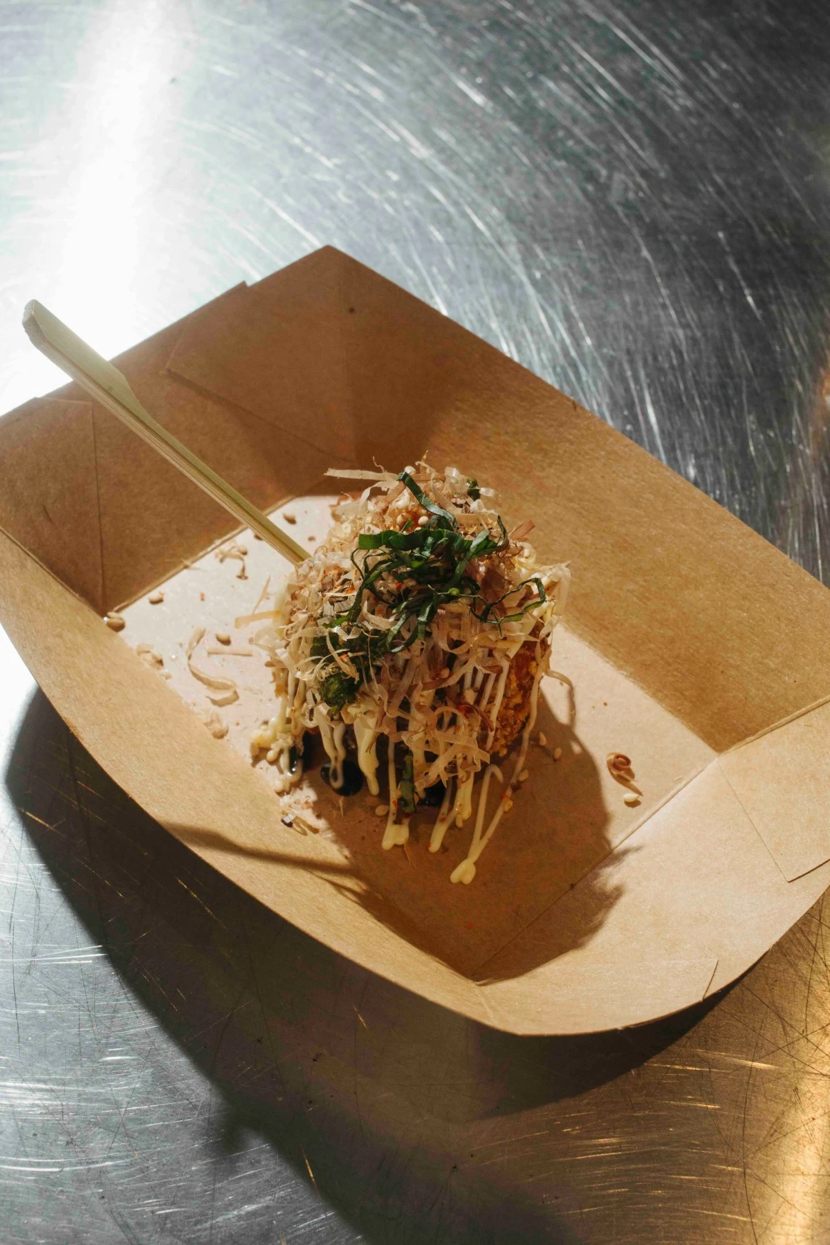 ARANCINI TAKOYAKI Crisp arancini served takoyaki-style, topped with pistachio pesto and balsamic reduction.