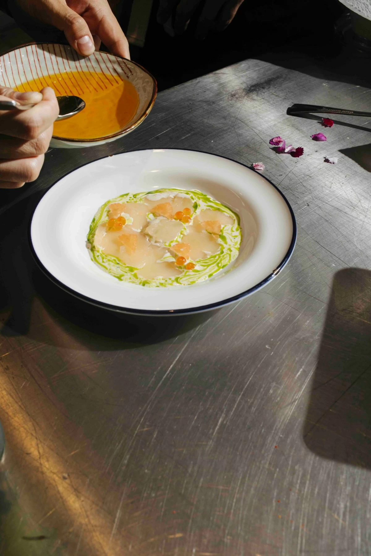 SCALLOP CRUDO Hokkaido scallops served thinly sliced with leche de tigre, grapefruit, and herb oil.