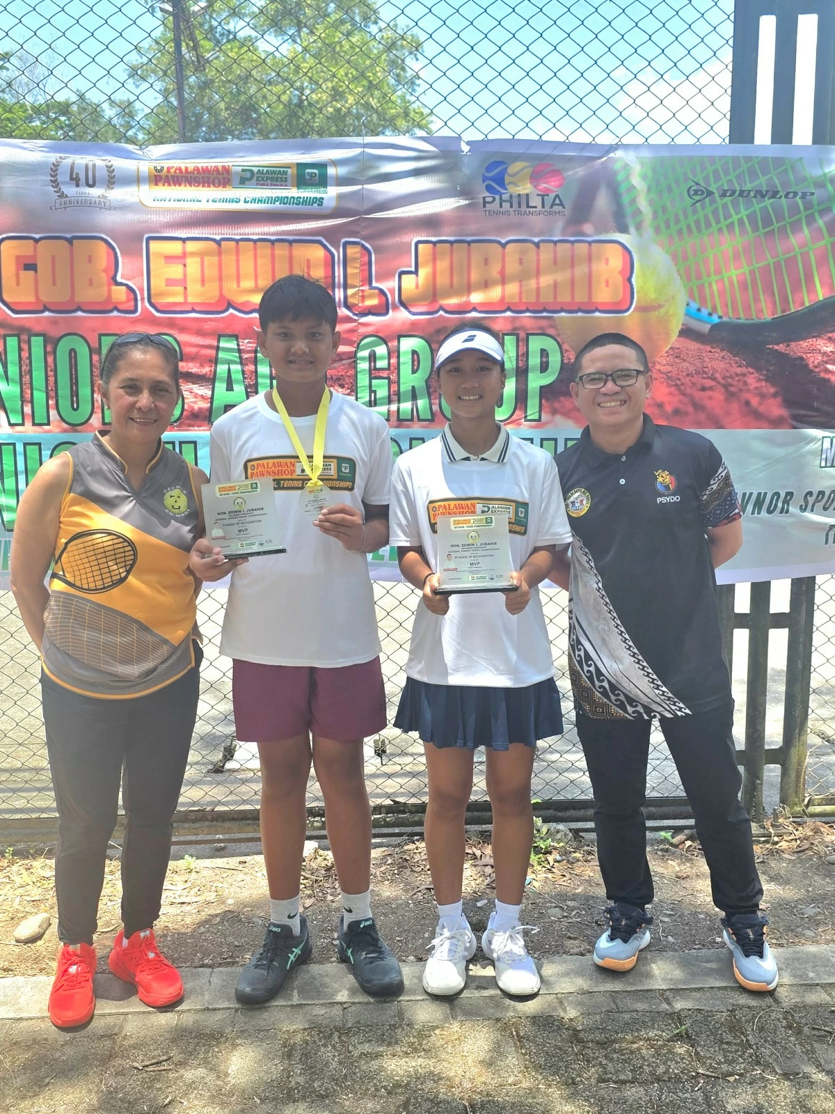 Kathlyn Bugna and Kresthan Belacas display their trophies after delivering impressive performances in Gov. Jubahib junior tennis tournament. With them are coach Jing Lobregas (left) and Philta board member Gilbert Paylado.