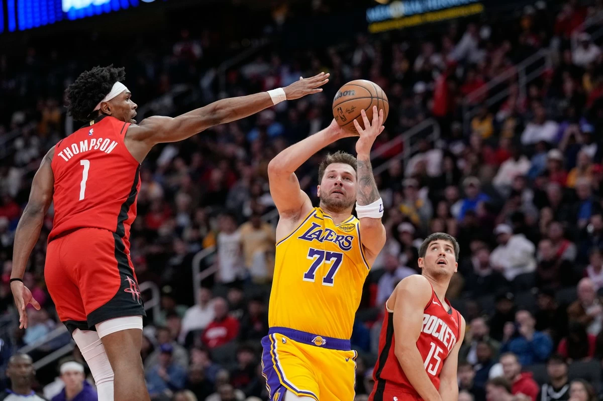 Los Angeles Lakers' Luka Doncic (77) shoots as Houston Rockets' Amen Thompson (1) defends during the first half of an NBA basketball game Monday, March 16, 2026, in Houston. (AP Photo/David J. Phillip)