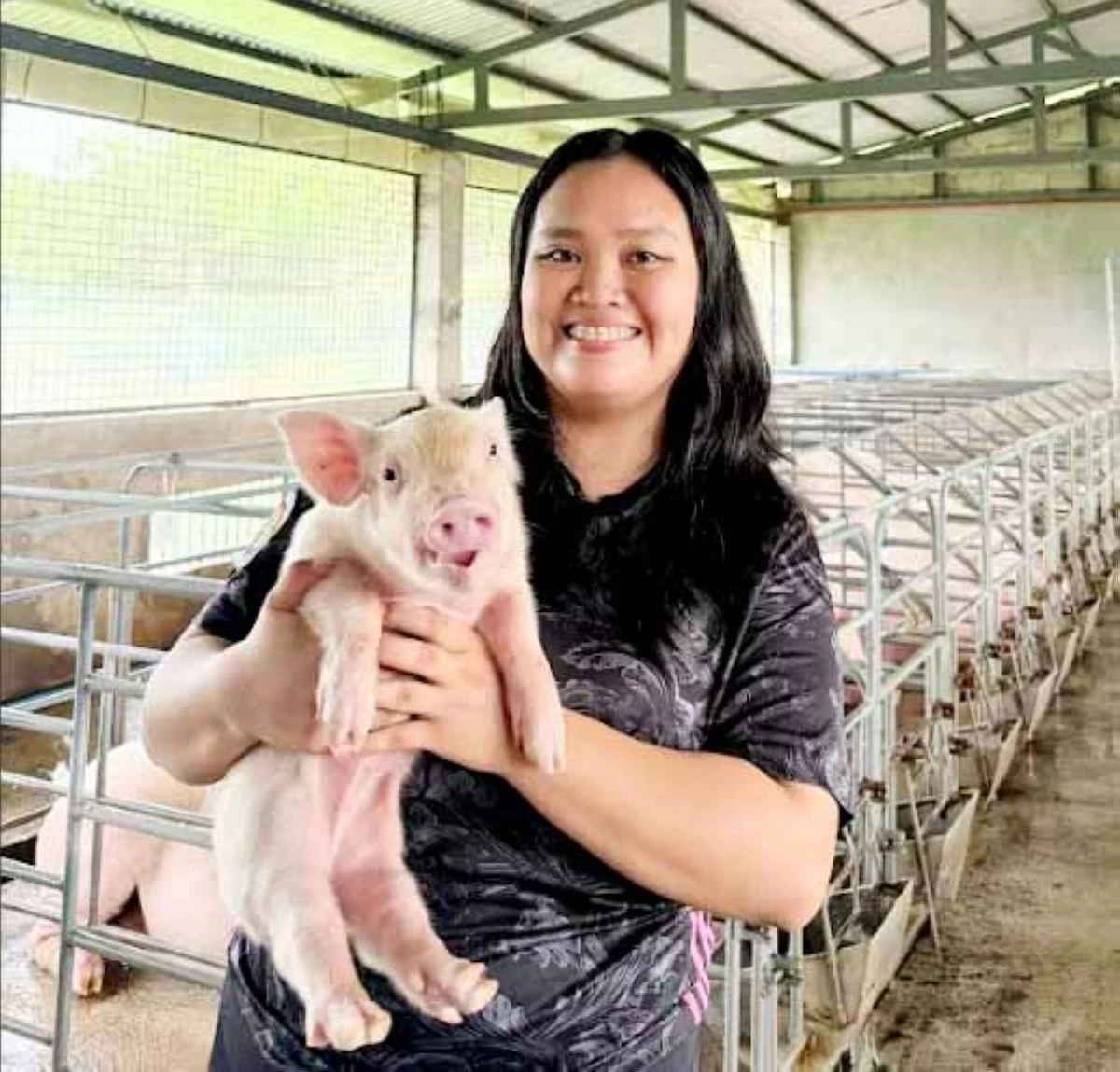 YOUNG FARMER — Kate Ashley Pattaui, owner of Kikay Farm, gently holds a piglet inside their piggery in Tuguegarao City, Cagayan.