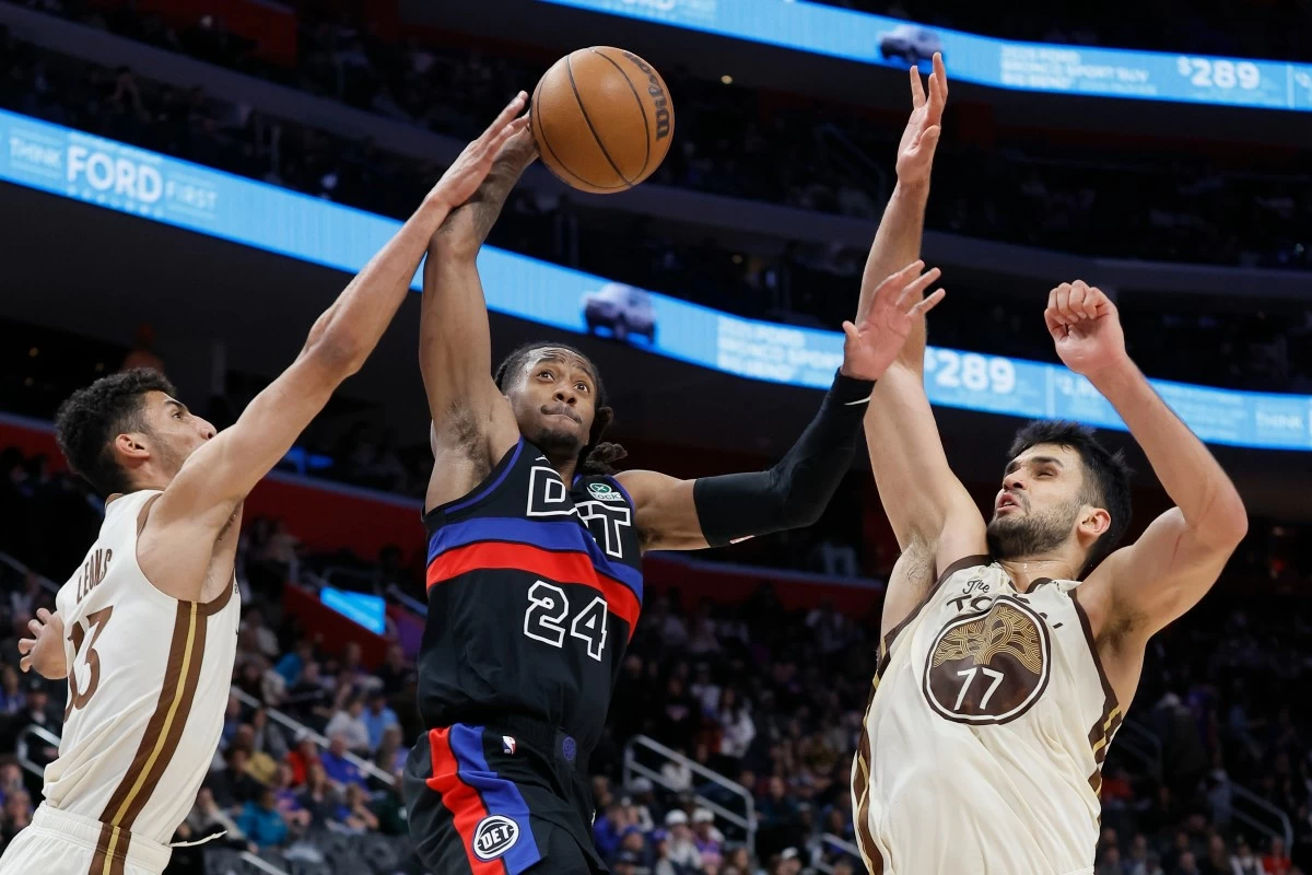 Detroit Pistons guard Daniss Jenkins, center, goes to the basket between Golden State Warriors forward Malevy Leons, left, and center Omer Yurtseven, right, during the second half of an NBA basketball game Friday, March 20, 2026, in Detroit. (AP Photo/Duane Burleson)