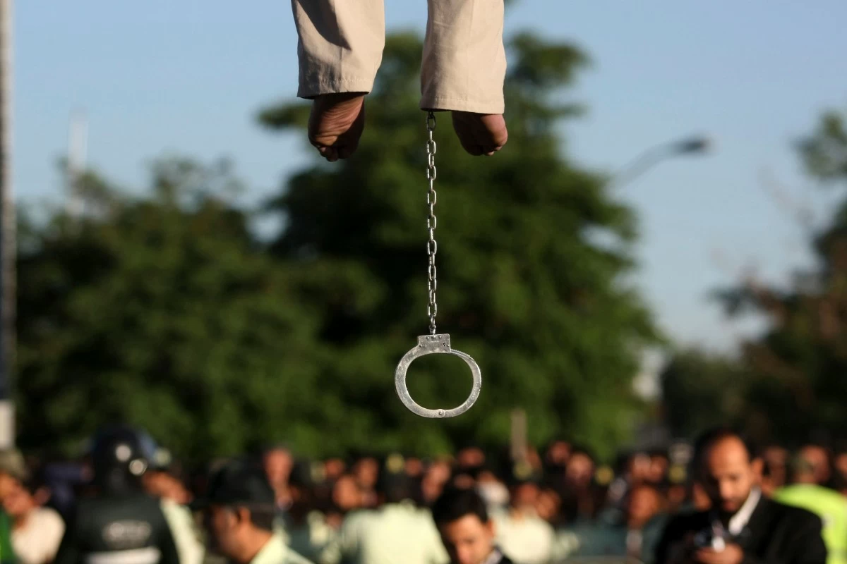 A SHACKLE hangs below the body of Mahdi Faraji, convicted of murder, during his public execution by hanging in the city of Qazvin, Iran, about 80 miles (130 kilometers) west of Tehran, Thursday, May, 26, 2011. (Hamideh Shafieeha/Mehr News Agency via AP, File)
