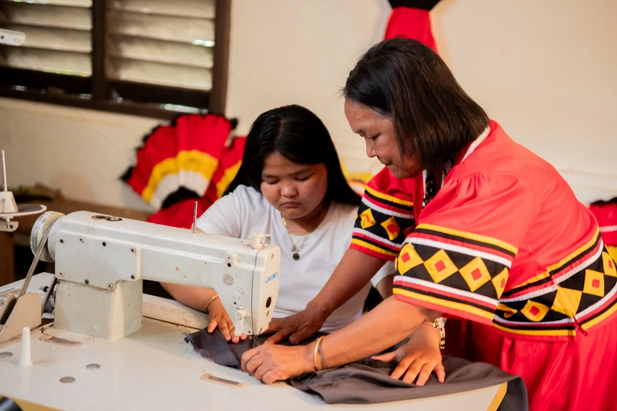 Master seamstress. Cherlie Tundanay (left) of the Higaonon tribe in Barangay Guihean, Bukidnon is one of the few remaining artisans skilled in sewing traditional tribal attire. She sees mentorship as a way to keep the tradition alive in future generations.