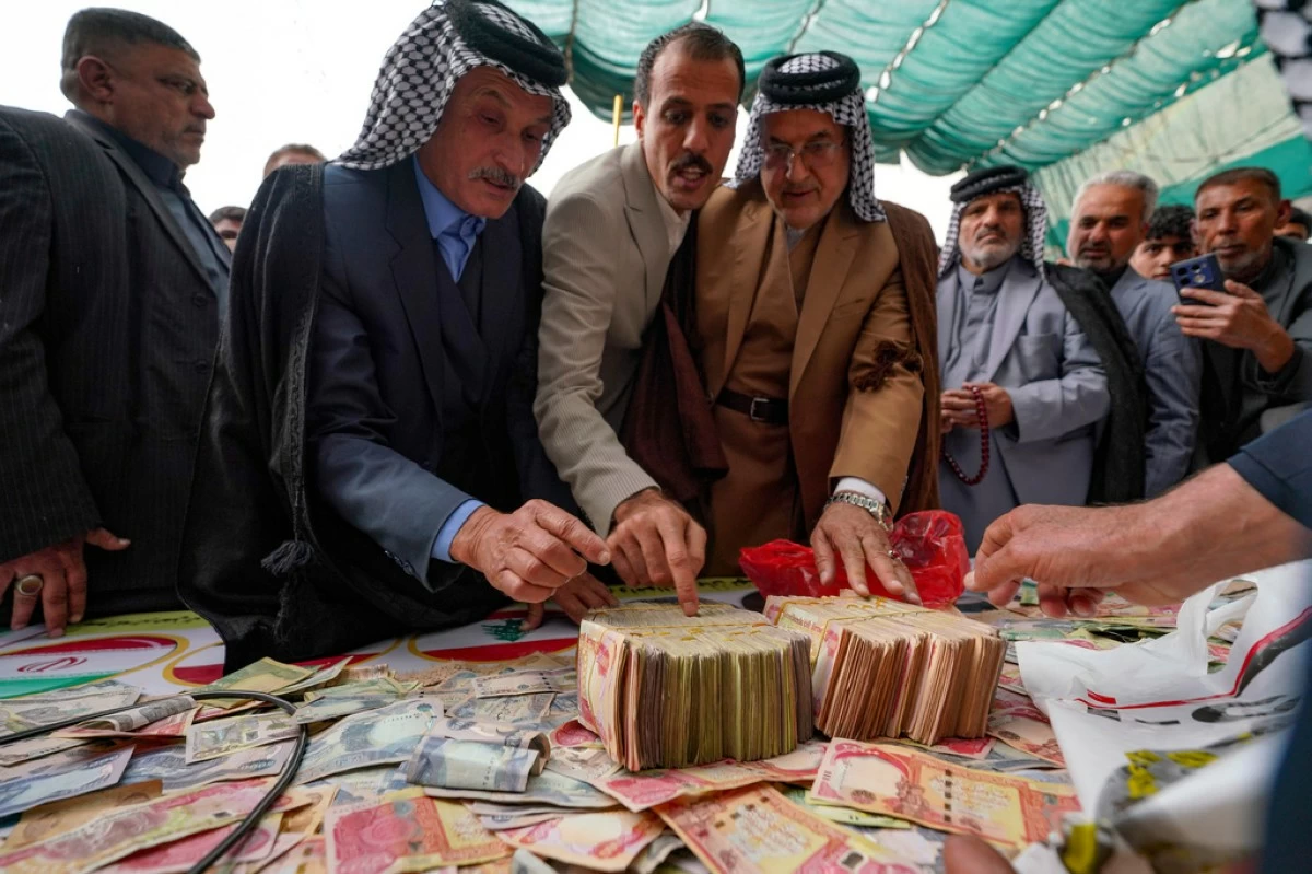 People donate money following a call by Grand Ayatollah Ali al-Sistani to support Iran and Lebanon during the war with the U.S. and Israel, Friday, March 27, 2026, in Babylon, Iraq. (AP Photo/Anmar Khalil)