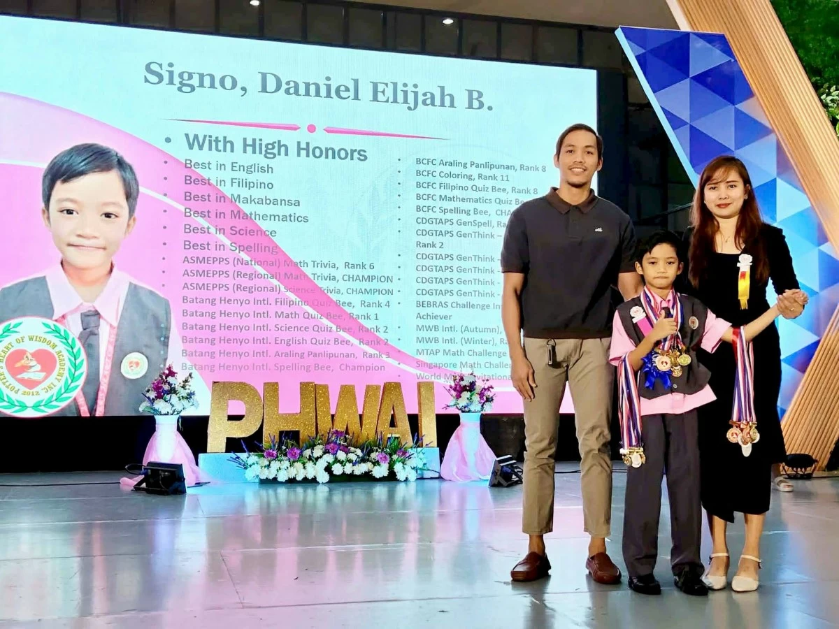Daniel Elijah Balino Signo, with his parents, Arvin and Jane Signo, during his school's recognition day in General Trias City on March 23 (Photo courtesy of Jane Signo/MANILA BULLETIN)