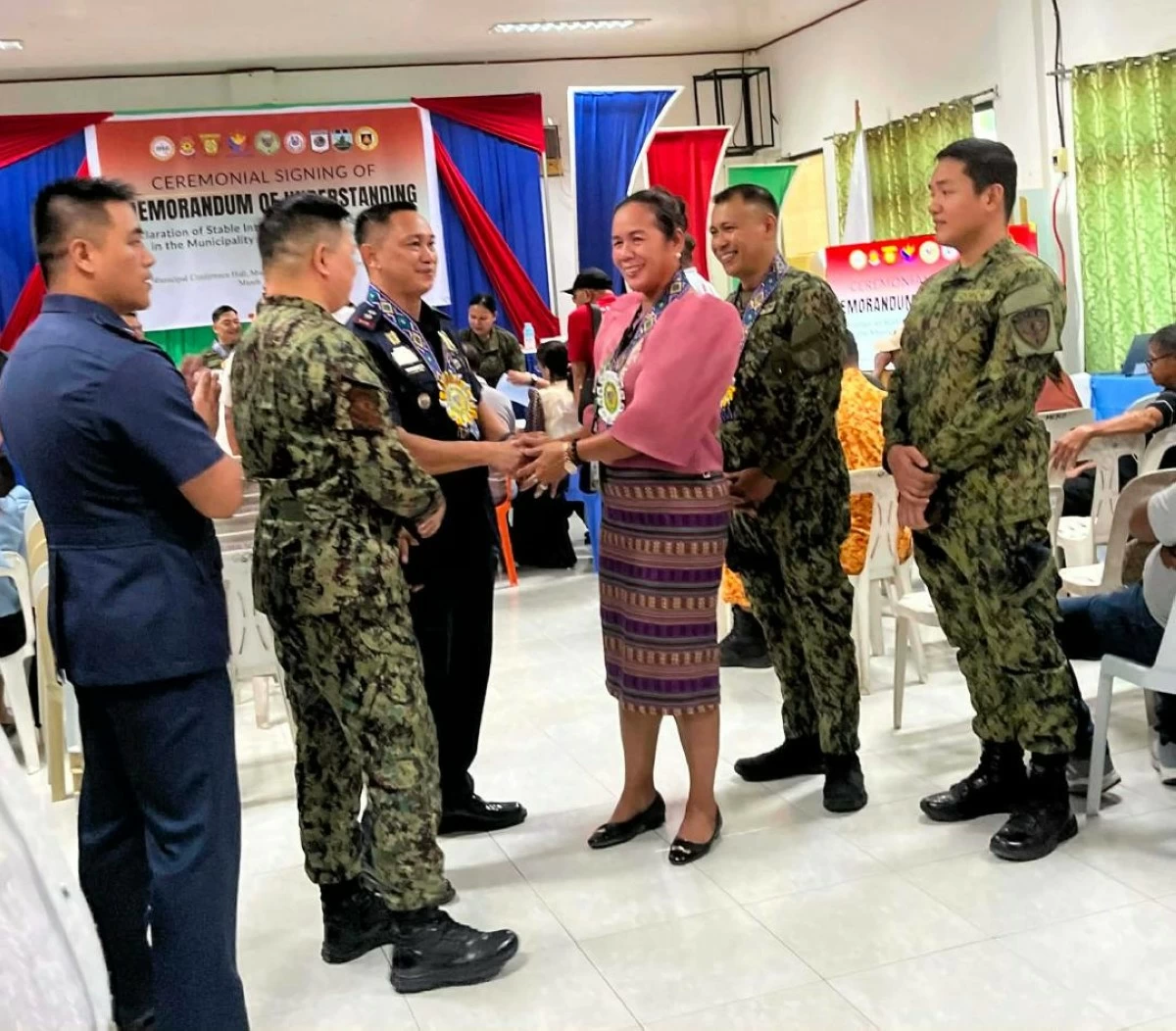 
MAYOR Teresita Ong of Gloria, Oriental Mindoro is congratulated by Lt. Col. Roden Fulache, deputy police director for administration of the Oriental Mindoro Police Provincial Office, and other police officers after her town was declared by the military under SIPS status on Monday, March 30. (Photo via Jerry Alcayde)
