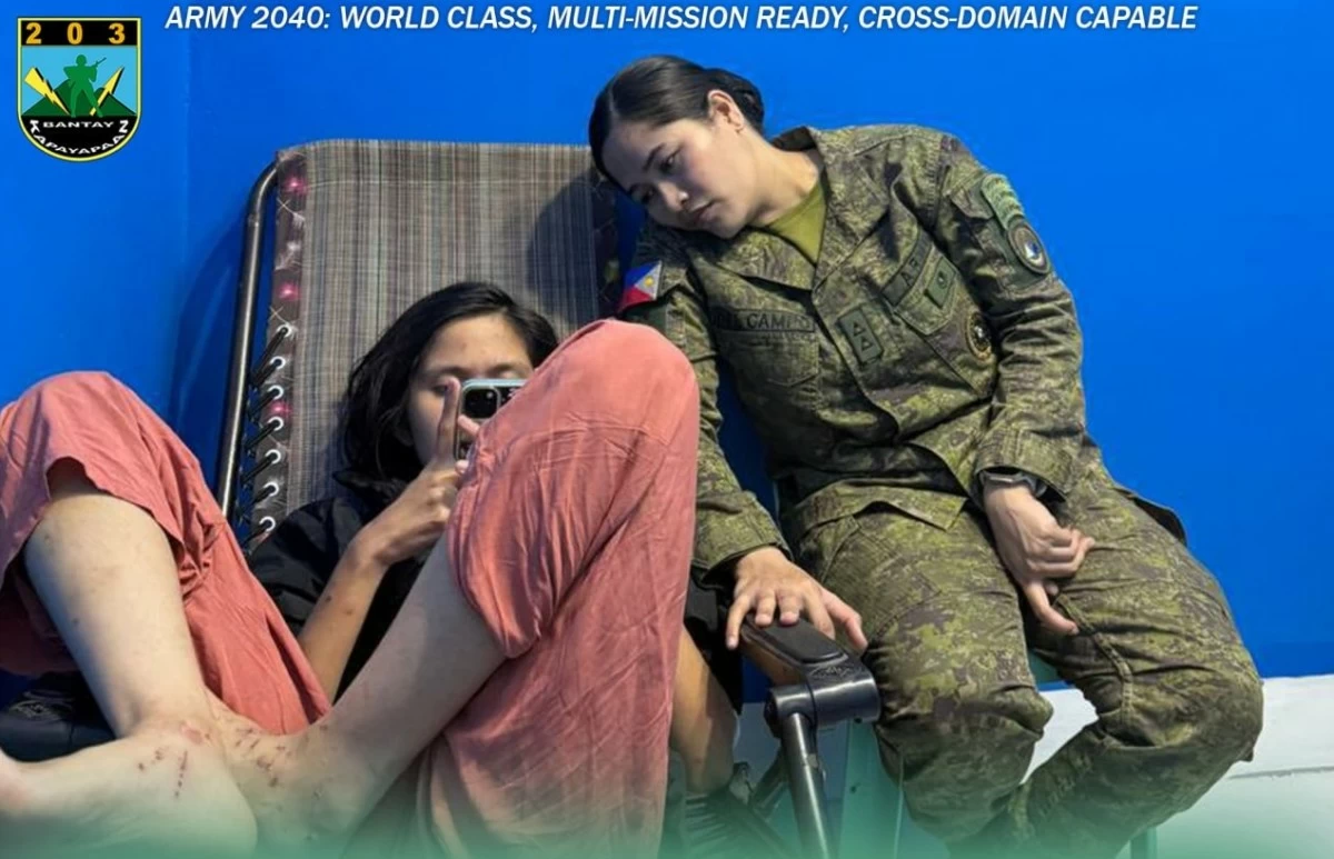 Charlize Cameron Garzon uses the cellphone of First Lt. Vina del Campo, a Philippine Army personnel, so she could contact her family. (Photo: 203rdIB)